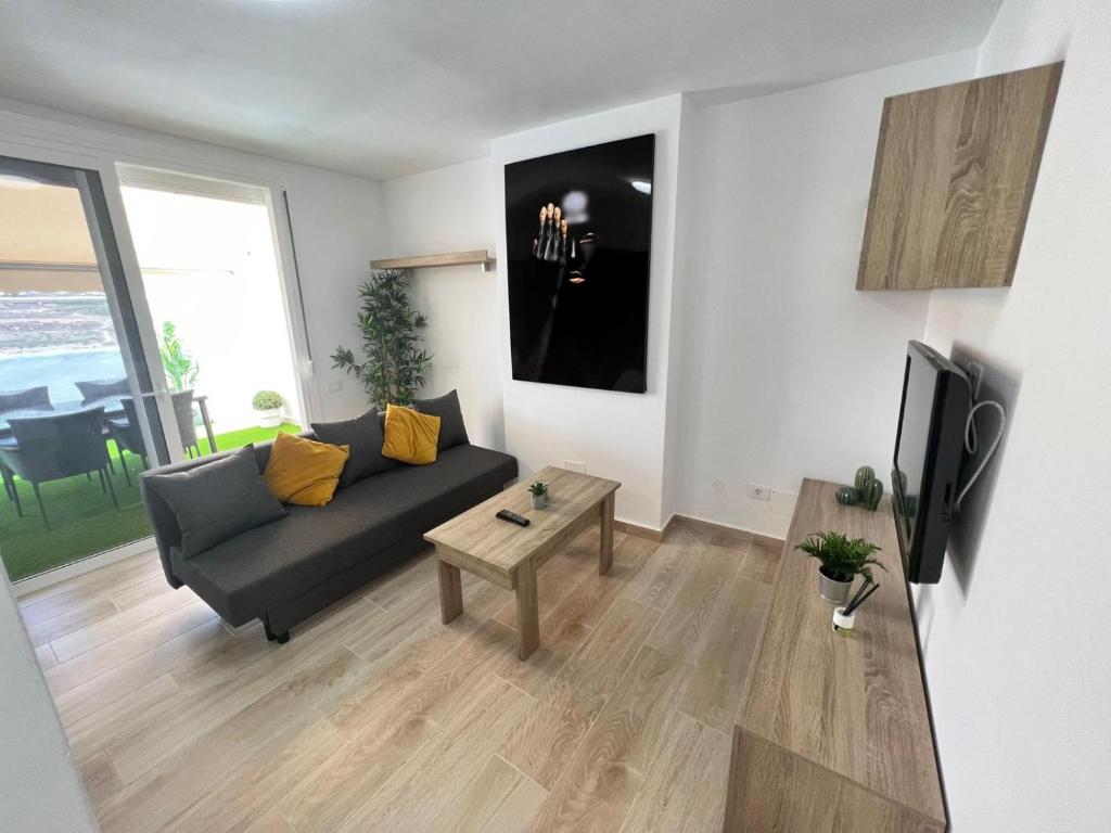 a living room with a couch and a tv at Precioso Atico Vista Teide in Las Galletas