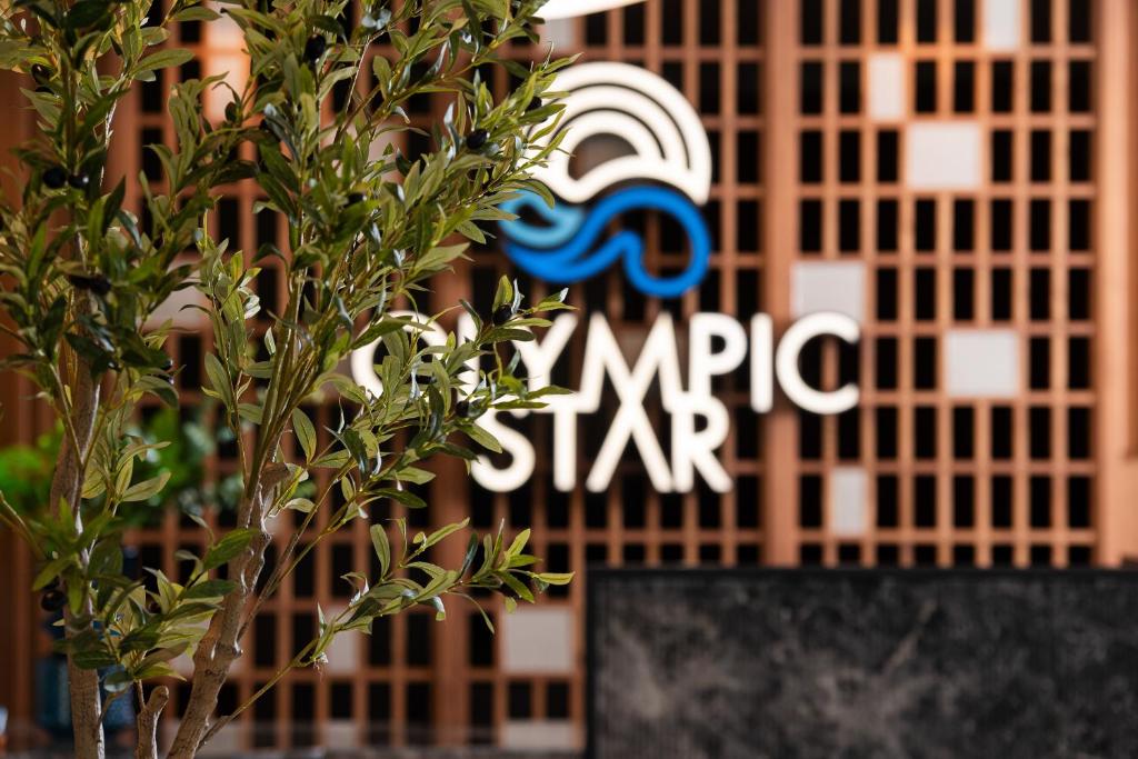 ネイポリにあるOlympic Star Beach Hotelの手前に木を背景に建つ建物