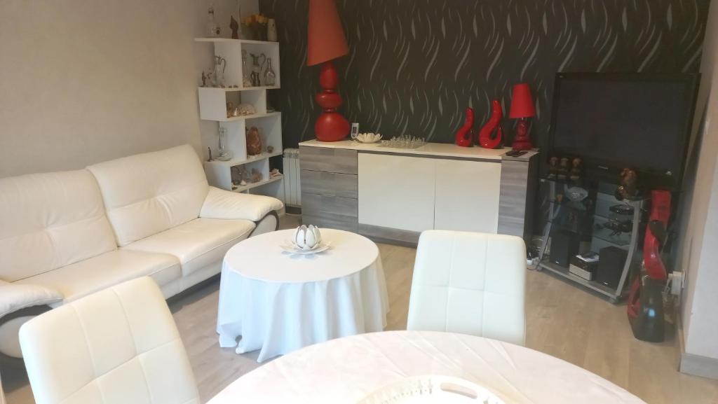 un soggiorno con un divano bianco e un tavolo di 25 Rue Raymond Braillard a Dole