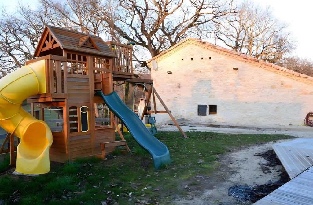 Un parque infantil con un tobogán y una estructura de juego. en Gite De Caractère En Pleine Nature, en Bourg-de-Visa
