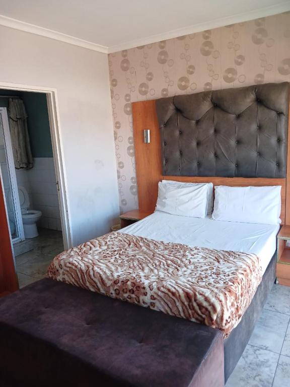 a bedroom with a large bed with a large headboard at Lookout Star Legend Accommodation in Parow