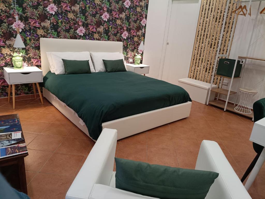 a bedroom with a large bed with a green blanket at Bilocale in Palazzo del XVI Secolo in Campobasso