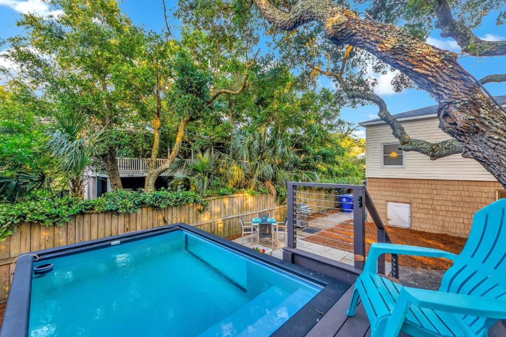 a patio with a hot tub and a blue chair at CM4005: 4005 Cameron Blvd. in Isle of Palms