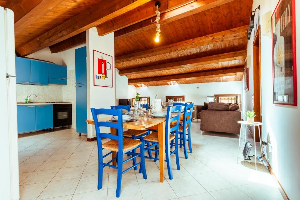 a dining room with blue chairs and a wooden table at Elegant Attic-Rovigo Center-6 people in Rovigo