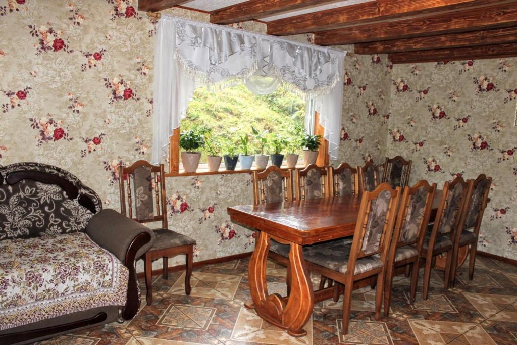 a dining room with a table and chairs and a window at Сільська садиба in Yablunytsya