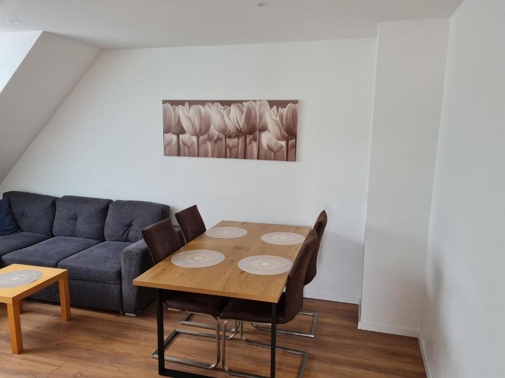 een woonkamer met een tafel en een bank bij Schöne Dachgeschoss Wohnung in Marl