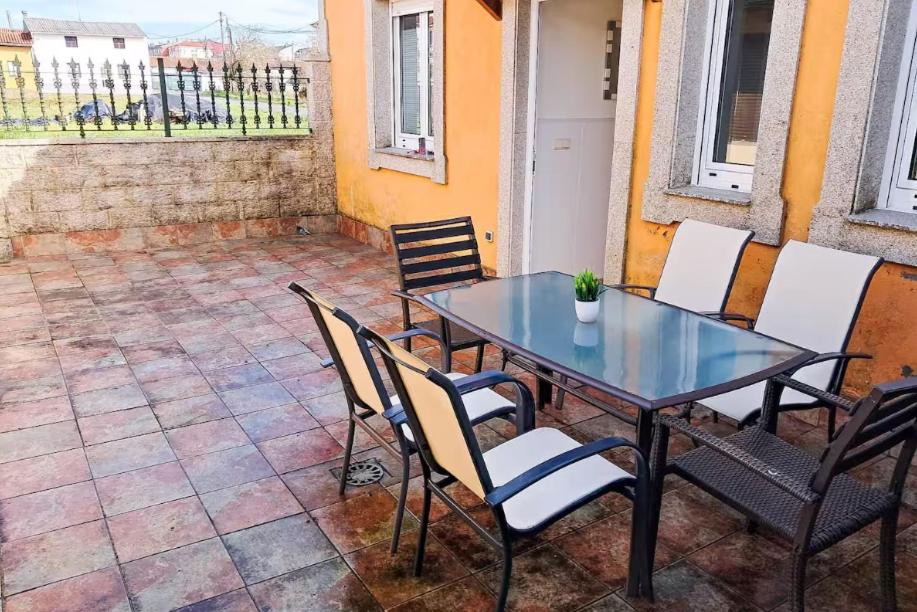 メリーデにあるCarmela Houseのガラスのテーブルと椅子が備わるパティオ