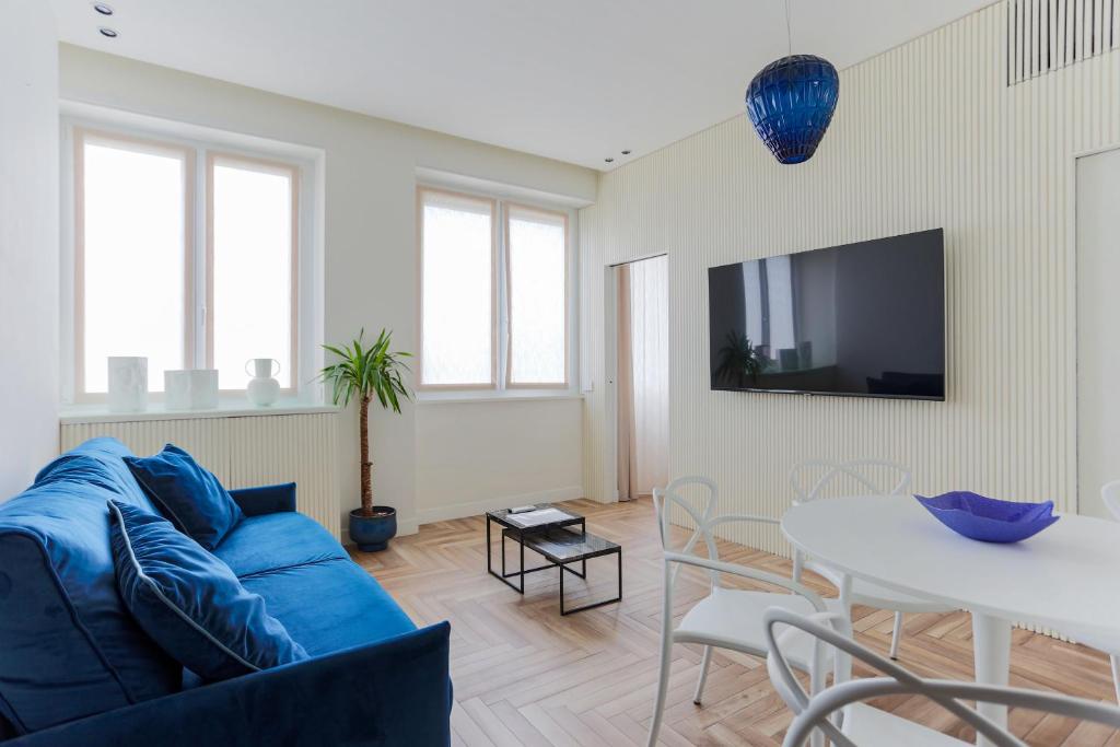 a living room with a blue couch and a table at YLS Luxury Suites 2 in Milan