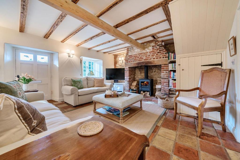 ein Wohnzimmer mit Couch und Kamin in der Unterkunft Ivy Cottage in Thornham