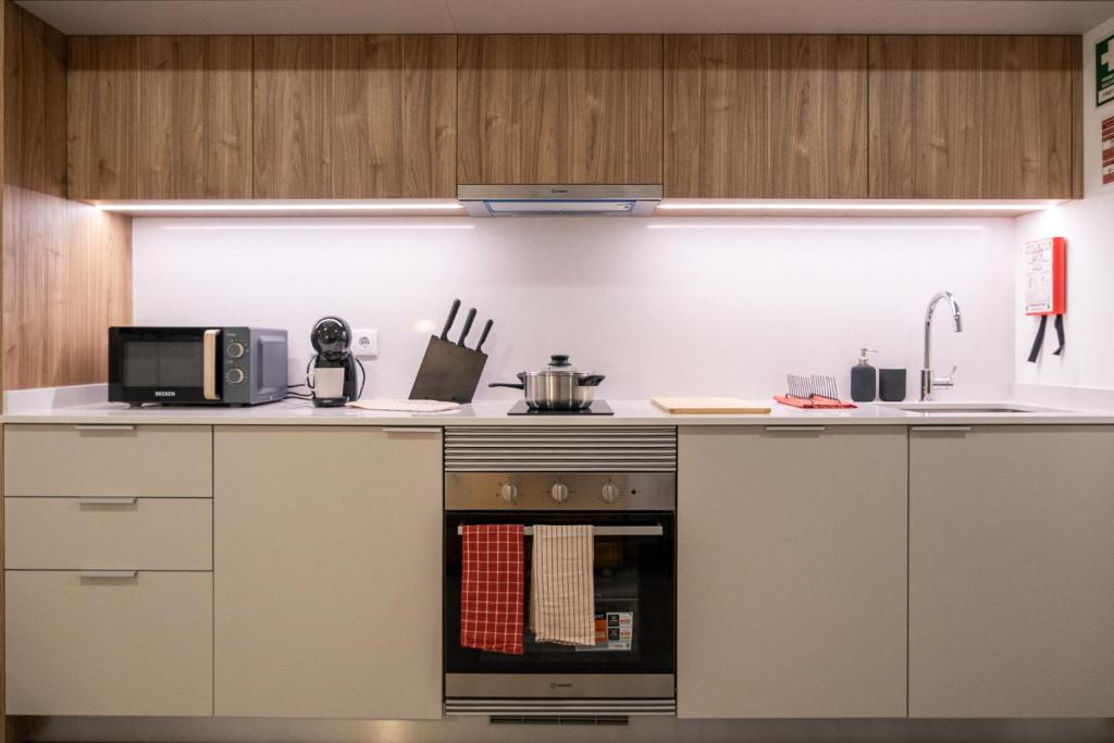 a kitchen with a stove and a microwave at Color Avenida T0 in Águeda