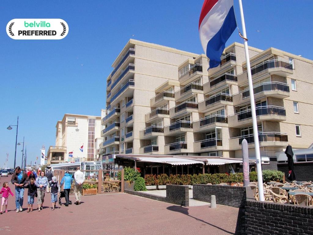people walking in front of a building with a flag at Apartment in Noordwijk near Beach in Noordwijk