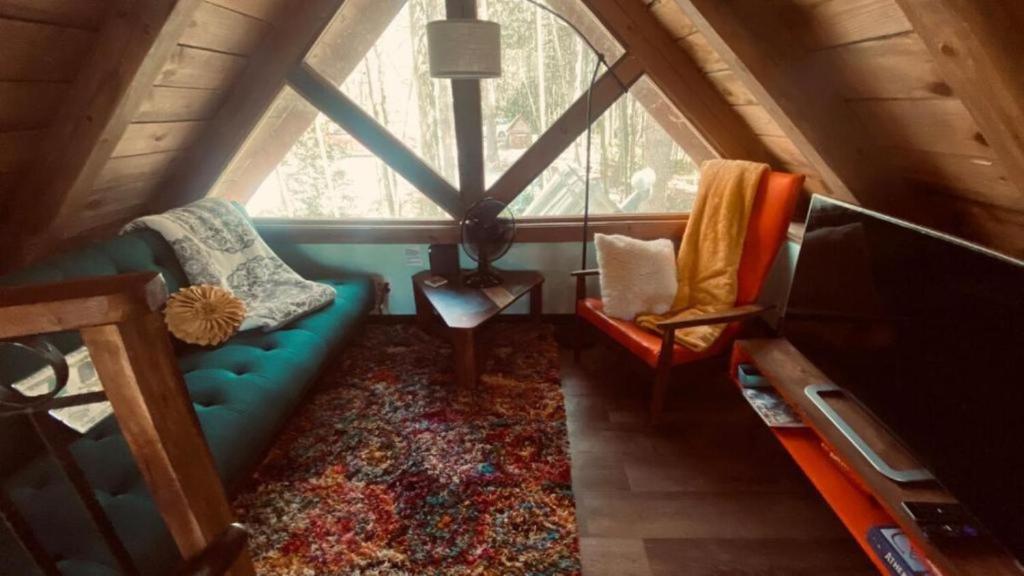 a living room with a blue couch and a window at Go Glamping in Athens, Georgia, in this Cozy Tiny House for Four in Athens