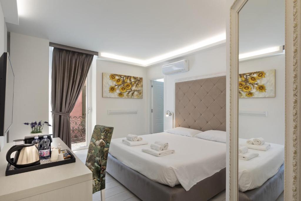 a bedroom with a large bed and a mirror at Isola nel Parco Villas & Rooms in La Maddalena