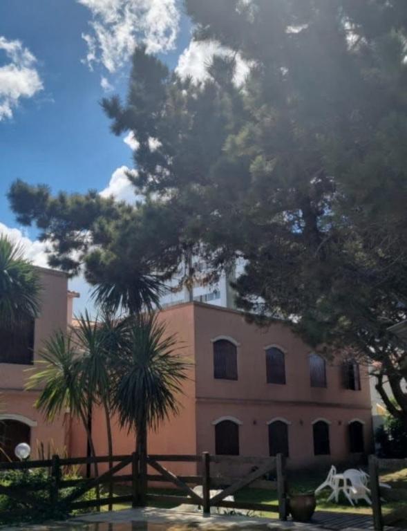 サンベルナルドにあるColonial suitesのヤシの木が目の前に広がるピンクの建物