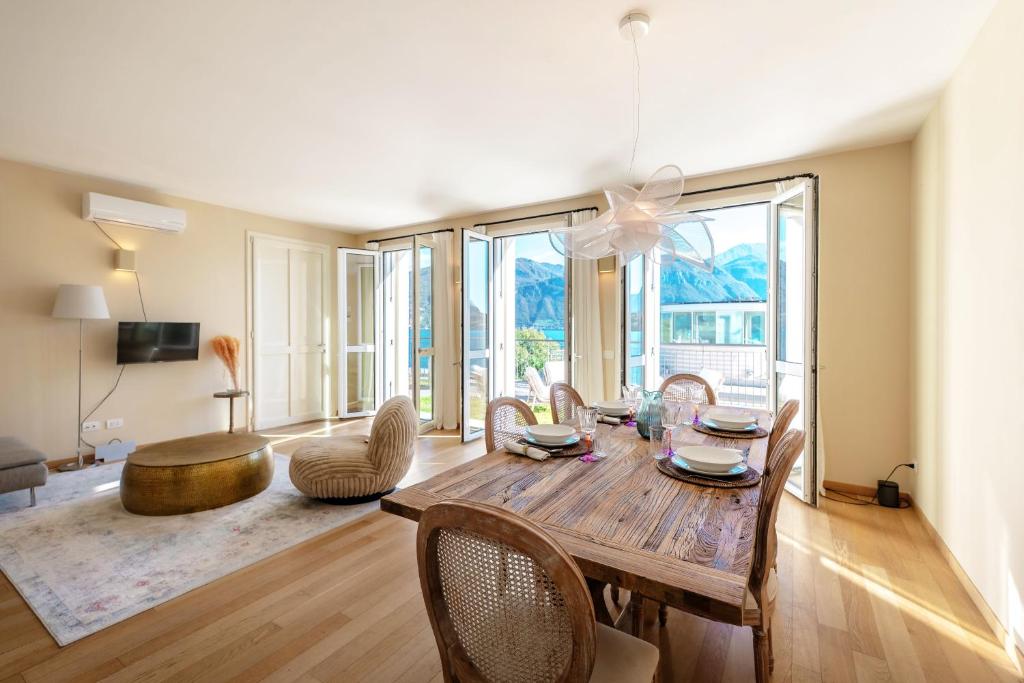 a living room with a wooden table and chairs at Residenza di Luce - by MyHomeInComo in Griante Cadenabbia