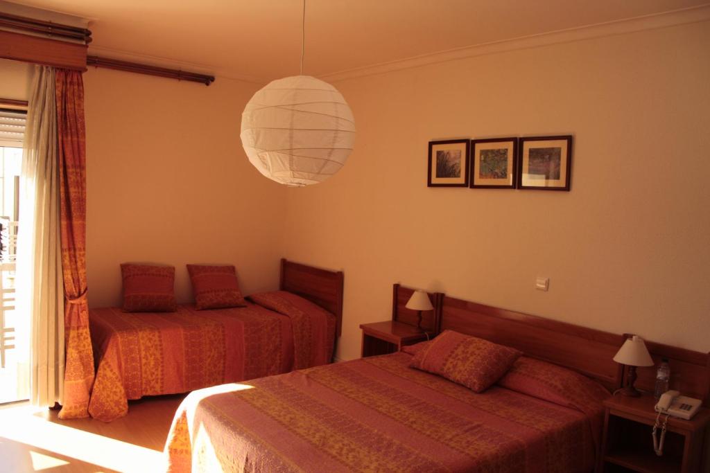 Postel nebo postele na pokoji v ubytování Residencial Dom Manuel