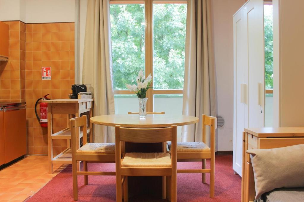 a dining room with a table and chairs and a window at Relax nel verde - WiFi & Parcheggio in Fanano