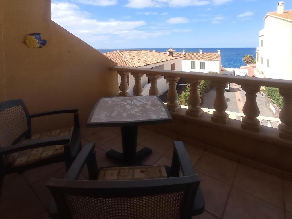 a balcony with a table and chairs and the ocean at Los Azahares Apartment in Costa Del Silencio
