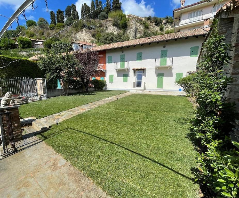 a house with a large yard with green grass at Sara Home in Guarene