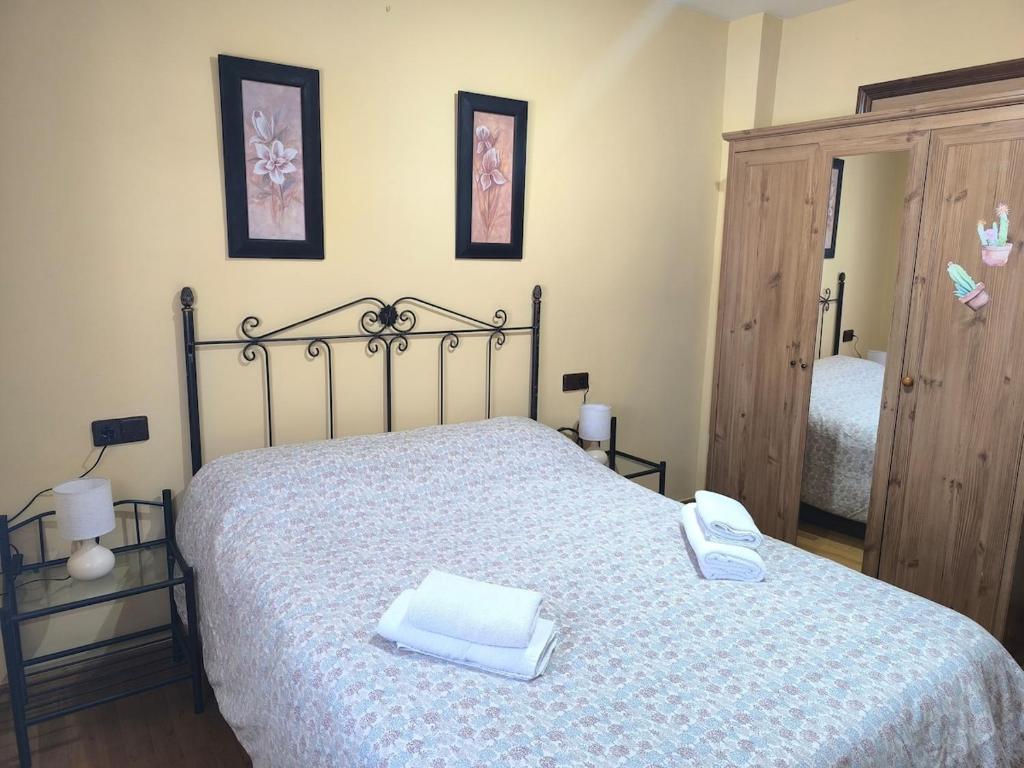 a bedroom with a bed with a blue and white blanket at El Dúplex del Monumento in San Juan de Aznalfarache