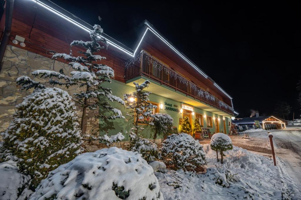 un edificio cubierto de nieve por la noche en Hotel Polovnik, en Demänovská Dolina