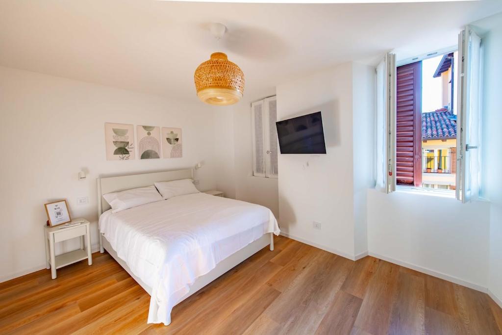 une chambre blanche avec un lit et une fenêtre dans l'établissement BGY Maison del Borgo 1, à Bergame