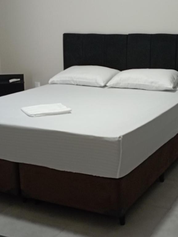 een bed met een zwart-wit bedframe bij Casa de Calmaria in Cordeirópolis