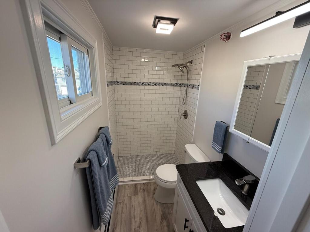 a bathroom with a shower and a toilet and a sink at Aqua Amour Studio in Old Orchard Beach
