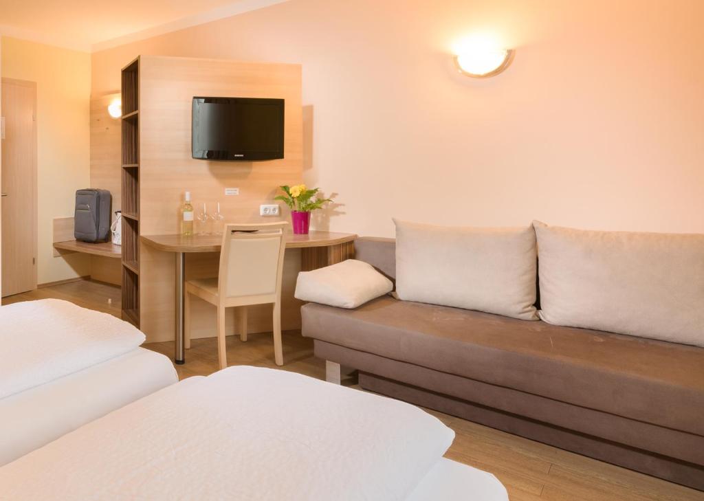 a living room with a couch and a table at Hotel Radlinger in Pellendorf