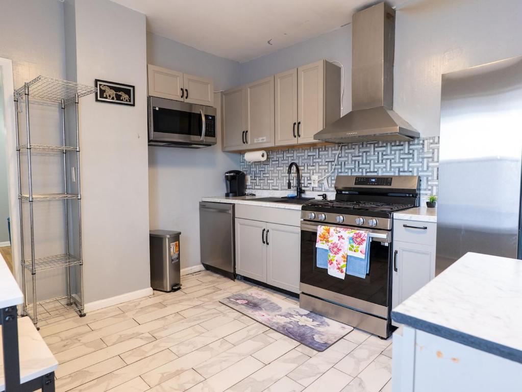 een keuken met witte kasten en een kookplaat oven bij New Apt in Elizabeth Railroad Style Path Train Bus Hospital Airport NYC in Elizabeth