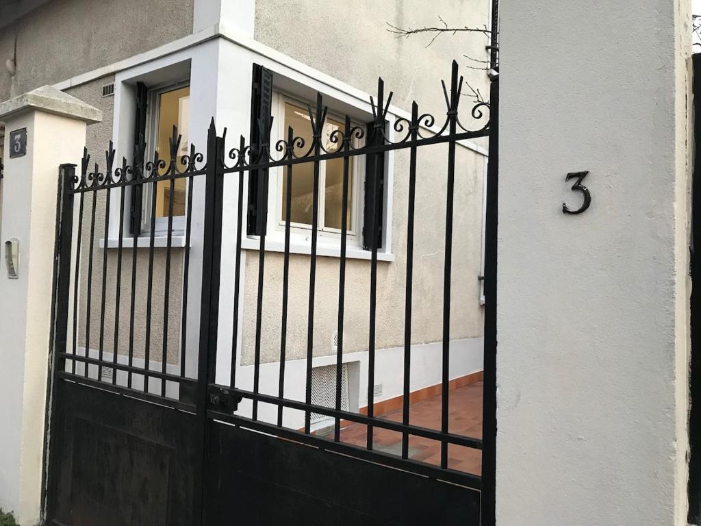 a black gate with a number on a house at Agréable appartement in Bobigny
