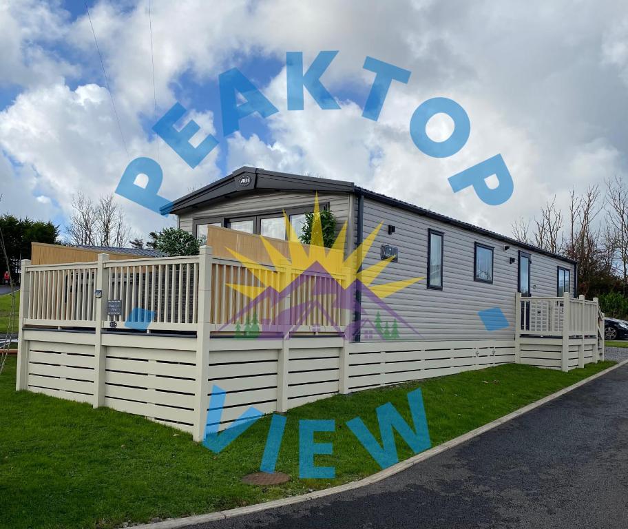 uma casinha com grafite na lateral de uma cerca em Peaktop View, Winscales, Cumbria em Winscales