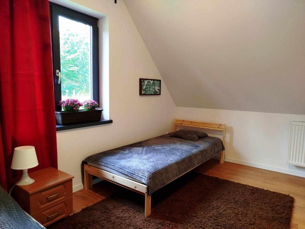 a bedroom with a bed and a window at Malëna Mausz in Parchowo