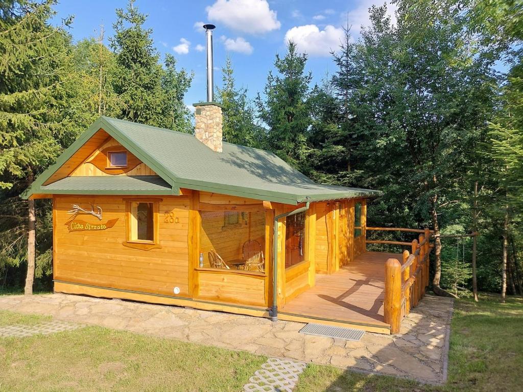 a large wooden cabin with a green roof at Cicha Strzała 