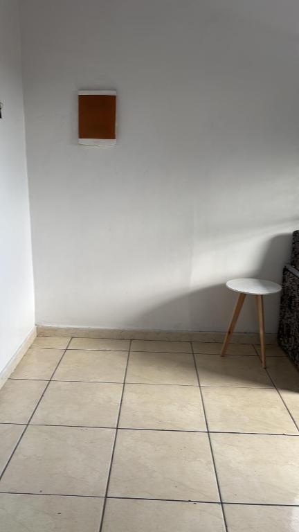 a white room with a table and a tiled floor at Casa 28 de agosto climatizada e aconchegante in Manaus