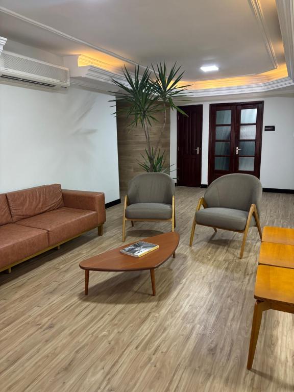 a living room with a couch and chairs and a coffee table at 44 Residence in Belém