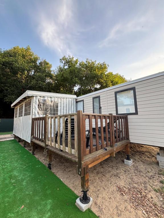 ein Haus mit einer großen Terrasse neben einem Gebäude in der Unterkunft mobil home in La Tremblade