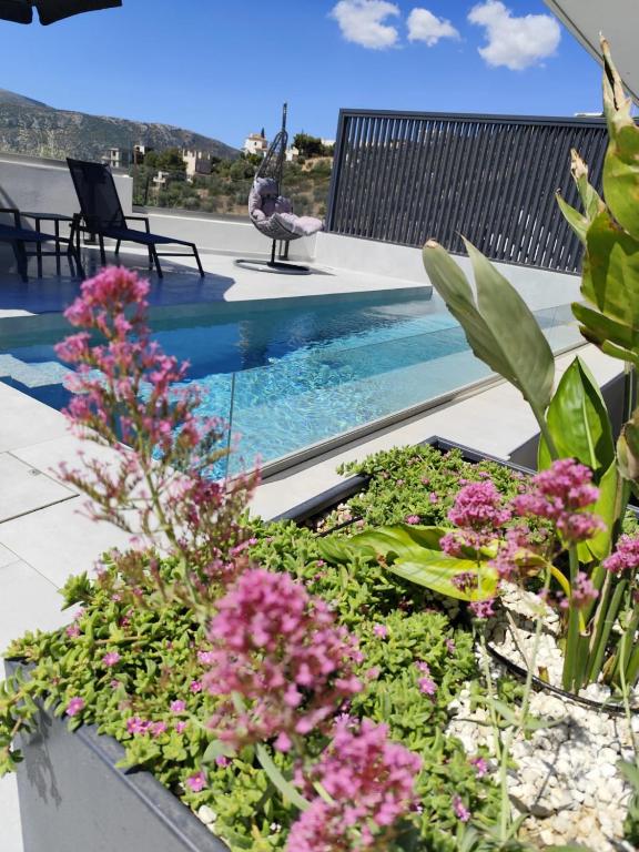 a patio with a swimming pool and flowers at Αriadne in Porto Rafti