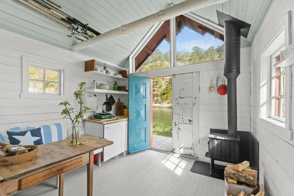 a kitchen with a blue door and a stove at 200-Year-Old House By The Southern Archipelago in Mandal