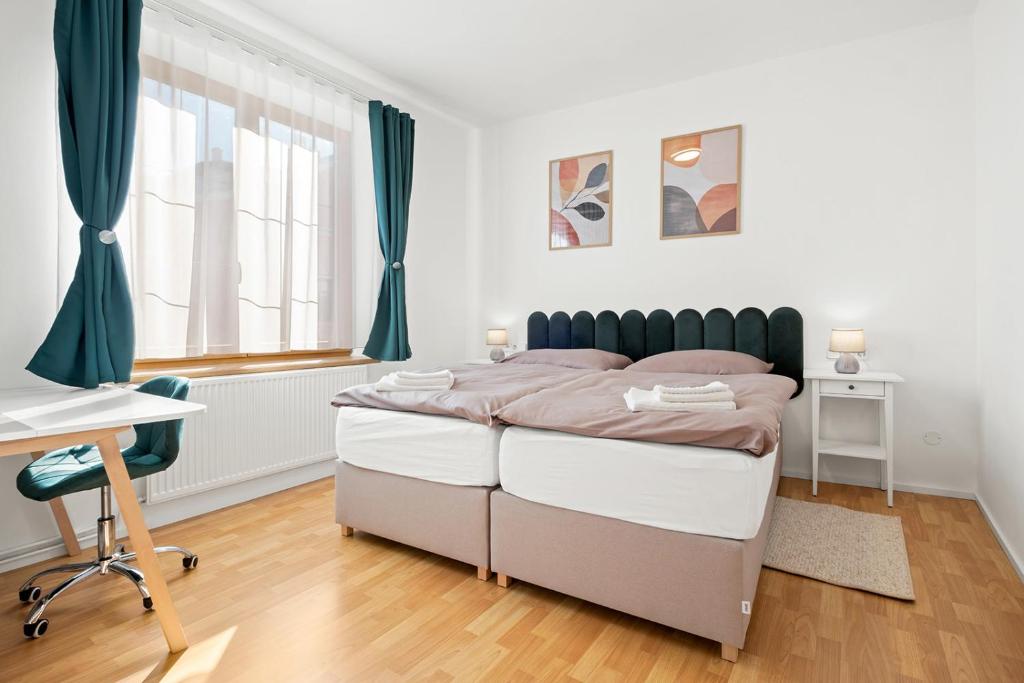 a bedroom with a bed and a desk and window at Ubytování Dva v centru in Velké Meziříčí