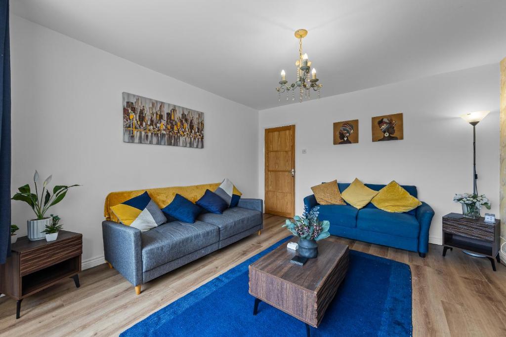 a living room with two blue couches and a table at Greenview in Spinney Hill