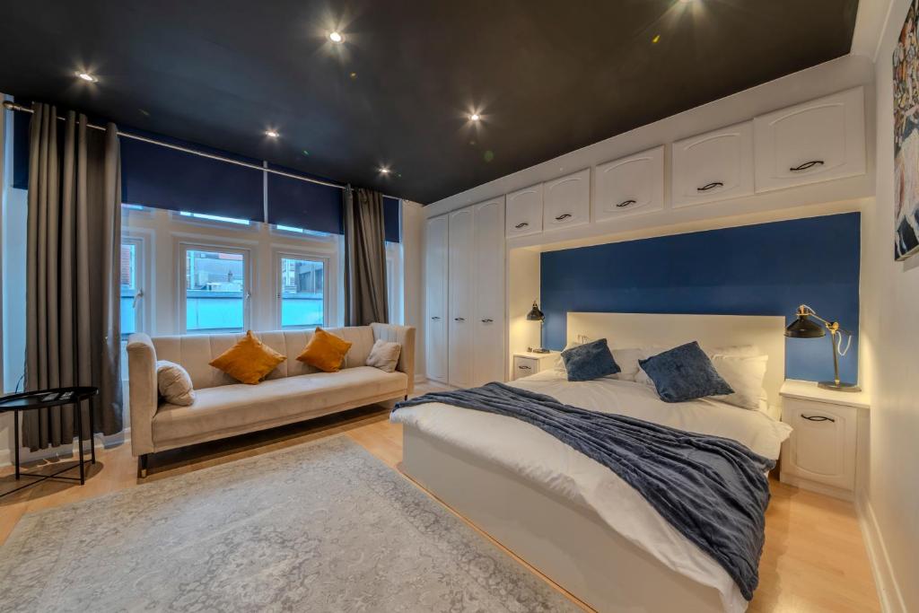 a bedroom with a large bed and a couch at Berwick Soho Suites by Aureva Residences in London