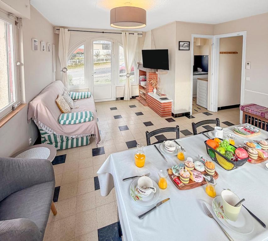 una sala de estar con una mesa con comida. en Marluis Mer - Apartment near dunes and beach, en Cucq