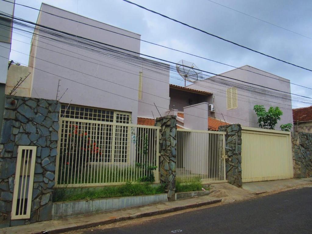 a white house with a fence in front of it at Solar dos Costais in Uberaba
