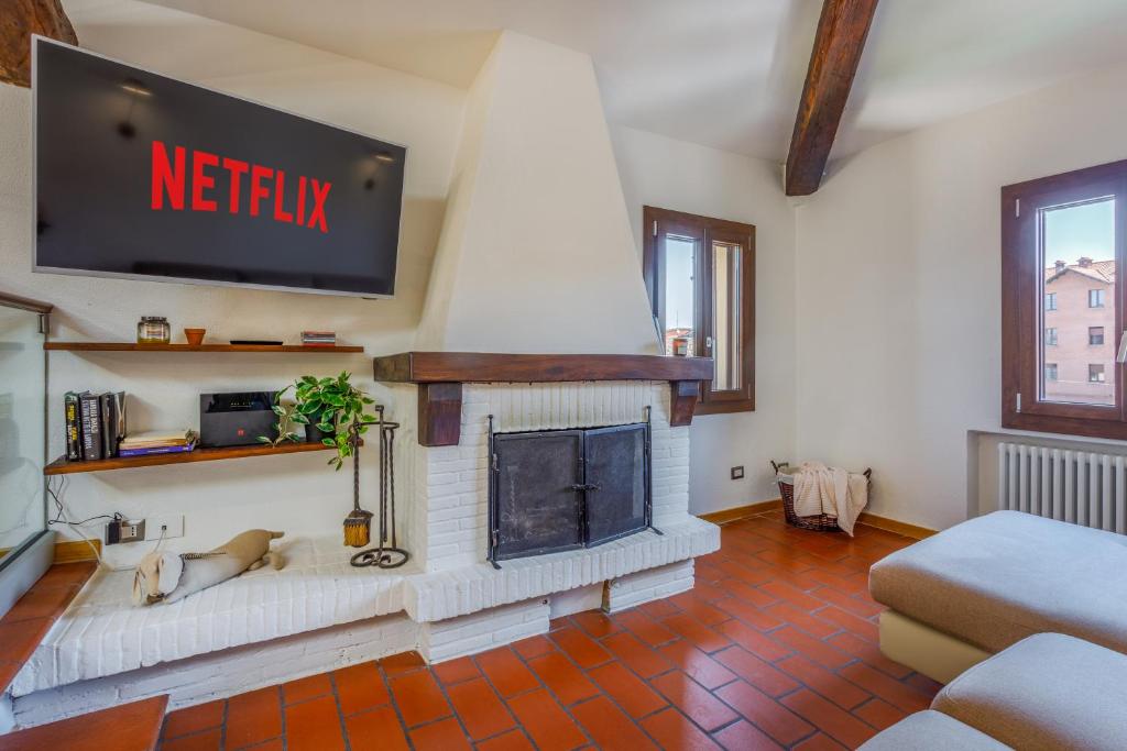 a living room with a tv and a fireplace at Little Cottage near Ferrari's City in Montale