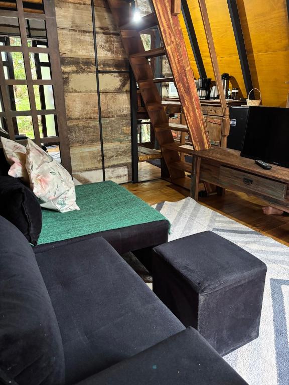 een woonkamer met een bank en een tafel bij Recanto - Chalé Boa Vista in Jaraguá do Sul