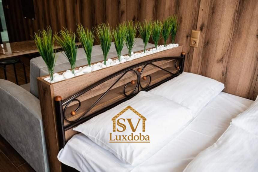 een bed met planten erop bij Нові смарт-квартири з парком і набережною! in Oezjhorod