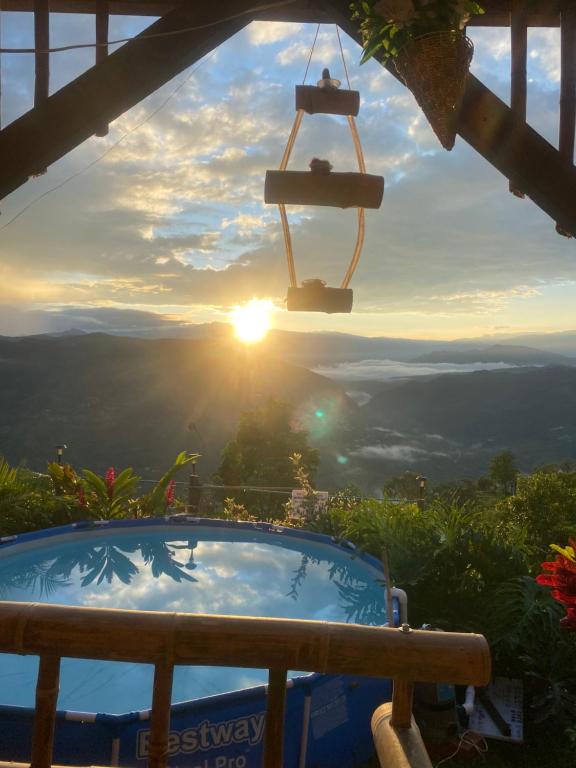 a hot tub with the sunset in the background at Cabaña el mirador del aguila in Quebradanegra