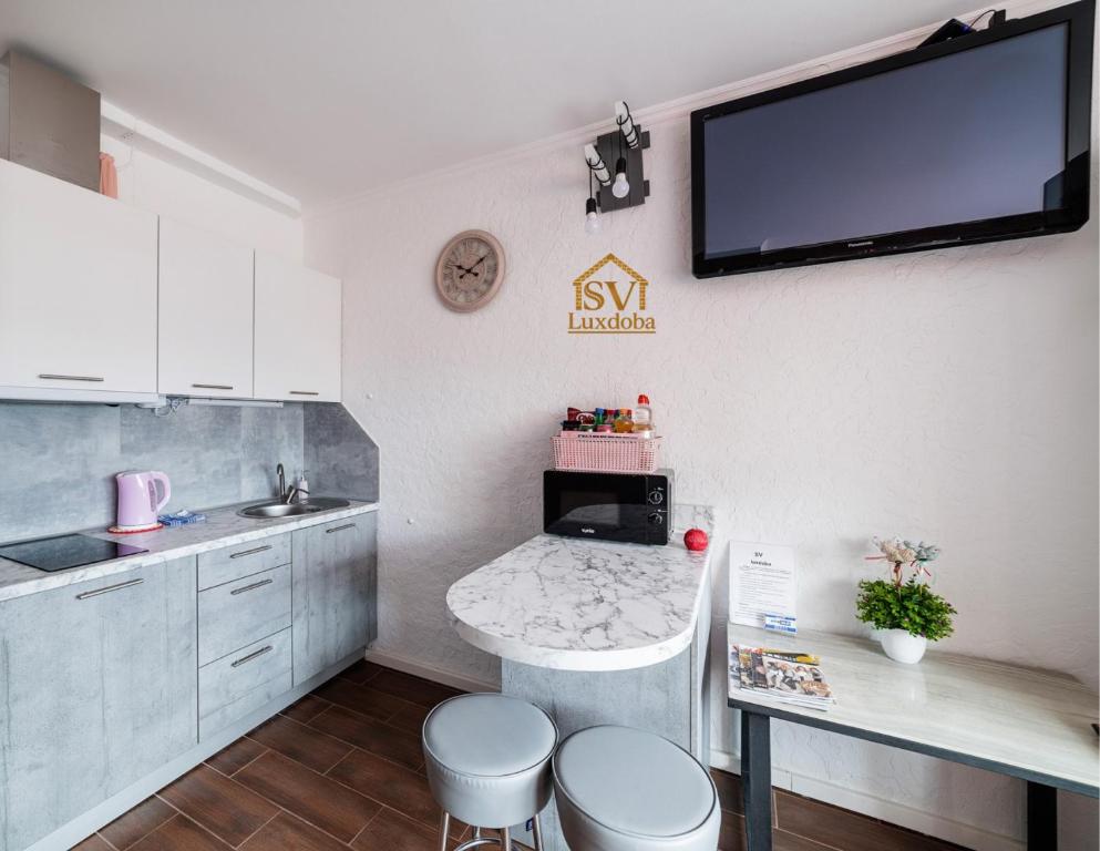 a kitchen with a sink and a tv on the wall at Найкраще розташування у місті Нові smart-квартири in Uzhhorod