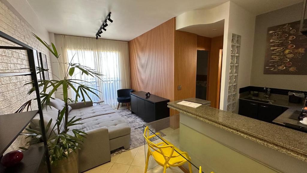 een woonkamer met een bank en een tafel bij Flat Vila da Serra in Nova Lima